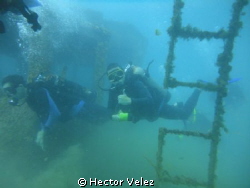My bigger son, diving among a sunken ship by Hector Velez 
